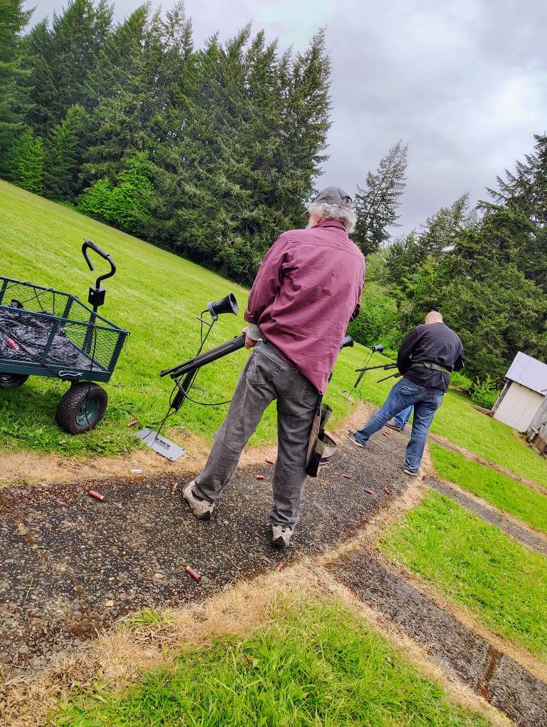 Two shooters walking the trap line with a target cart
